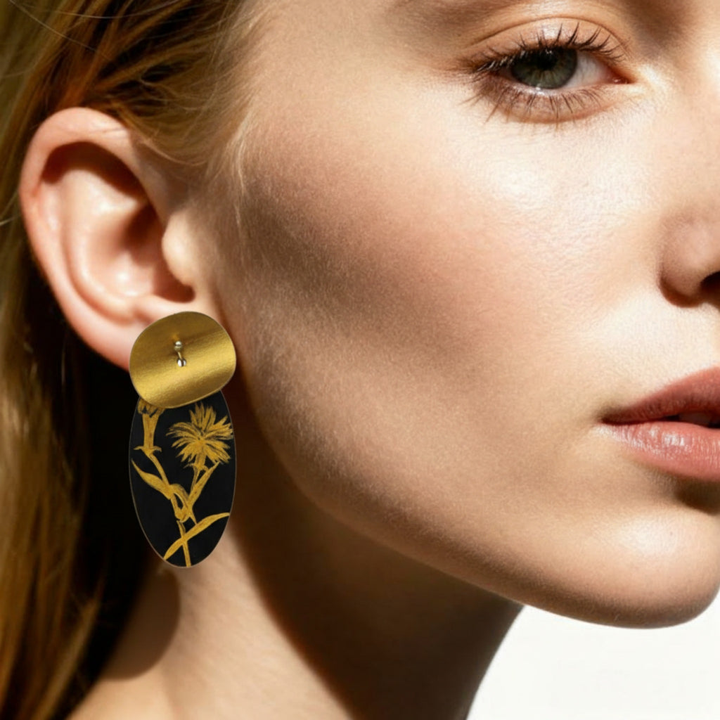 Close-up of a woman wearing gold and black earrings.