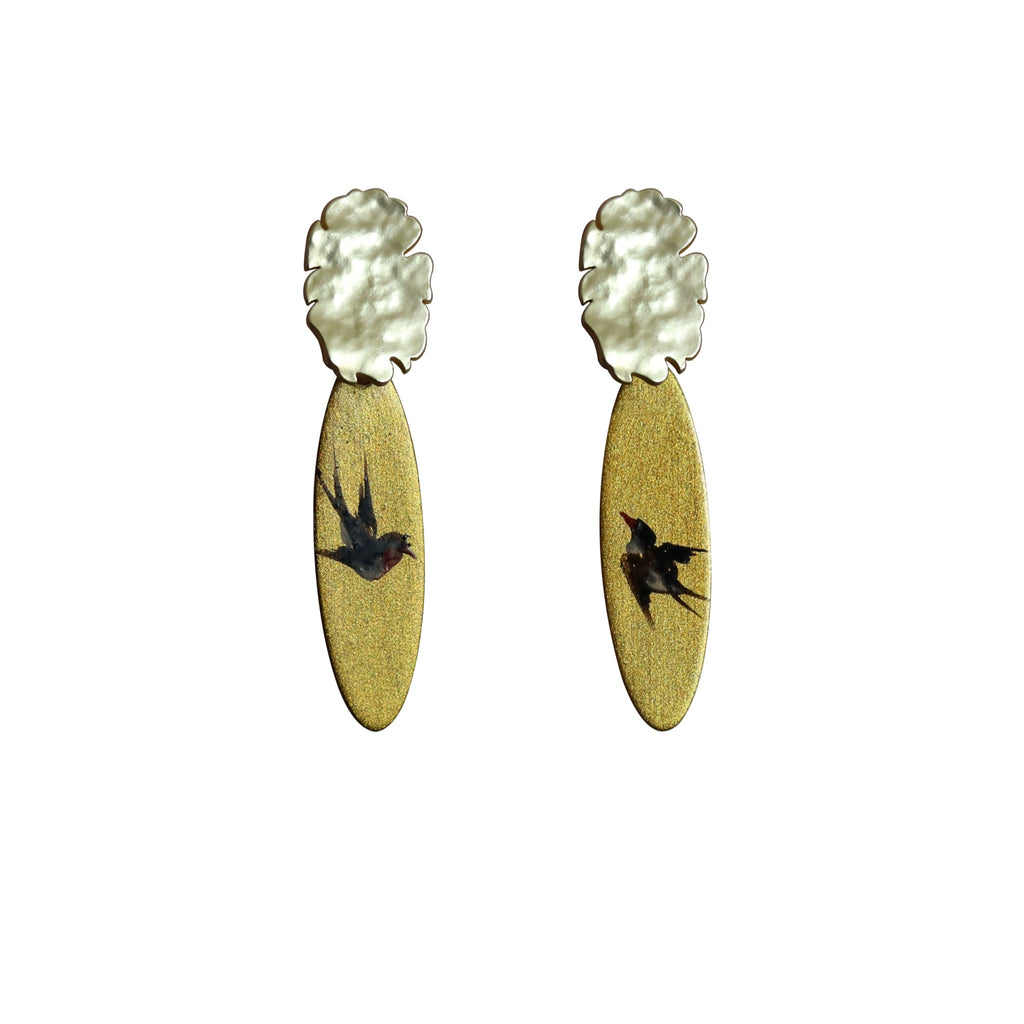 Pair of earrings with gold oval-shaped pendants and silver tops on a white background LacLume Lacquer Craft Hand Painted Flying Swallow Earrings