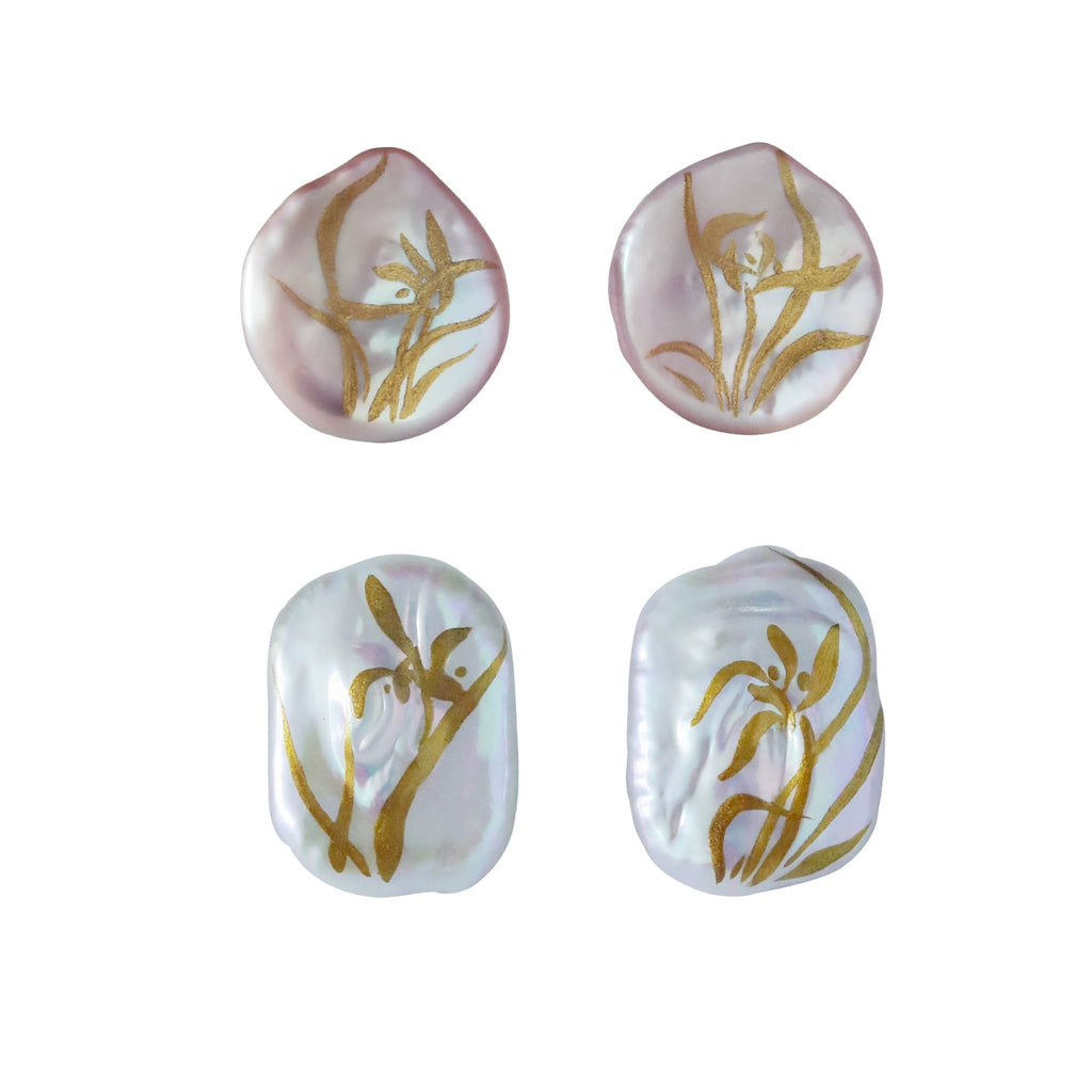 Four white pearls with gold floral patterns on a white background