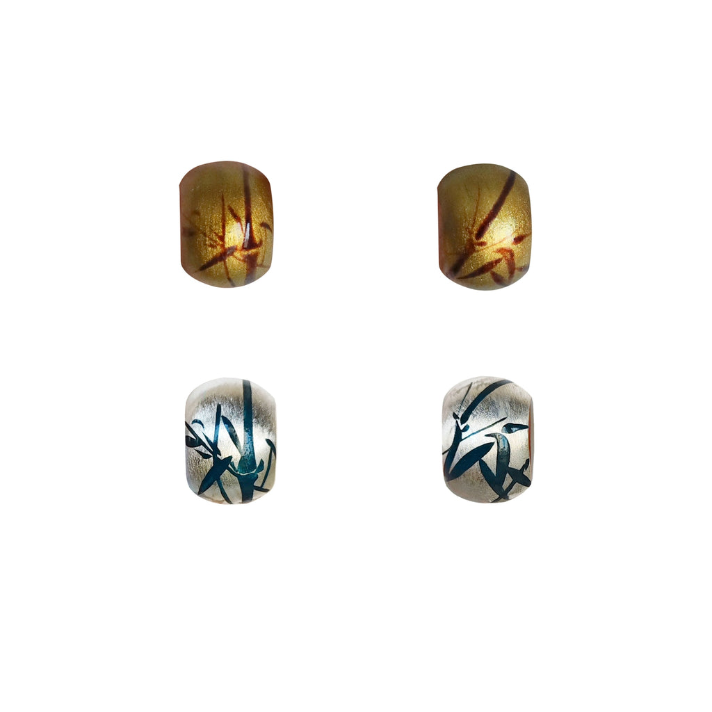 Four decorative beads with unique patterns on a white background