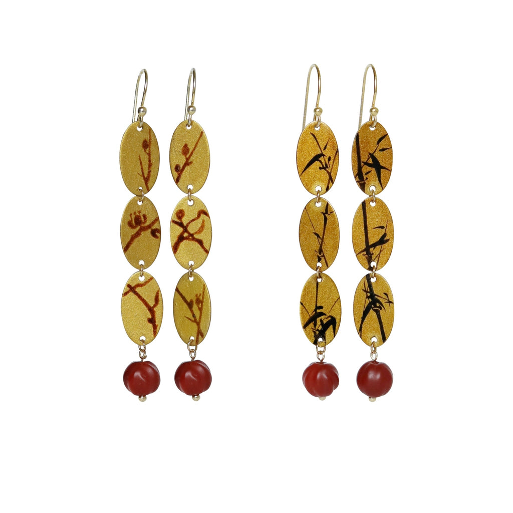 Pair of earrings with yellow and red beads on a white background