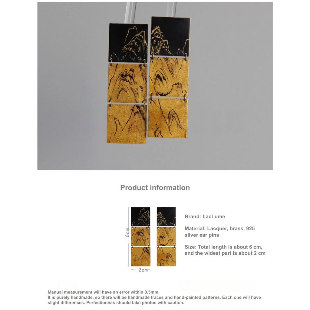 Pair of earrings with mountain design on a gray background