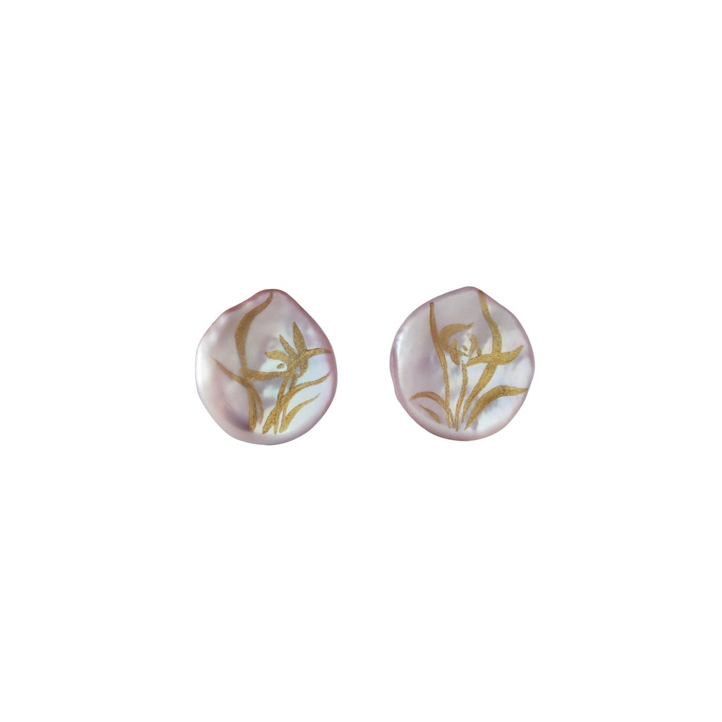 Pair of shell-shaped earrings with gold leaf design on a white background