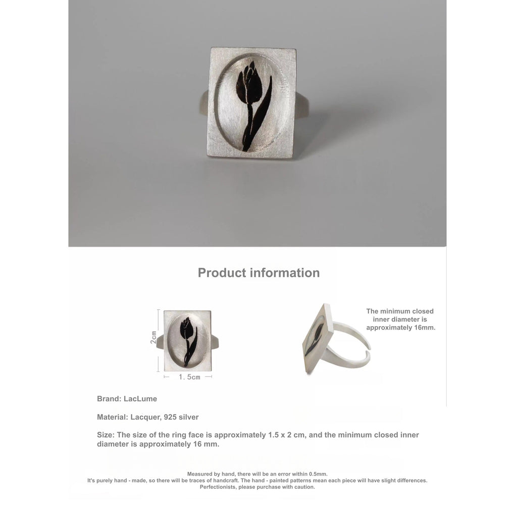 Silver ring with a black design on a gray background