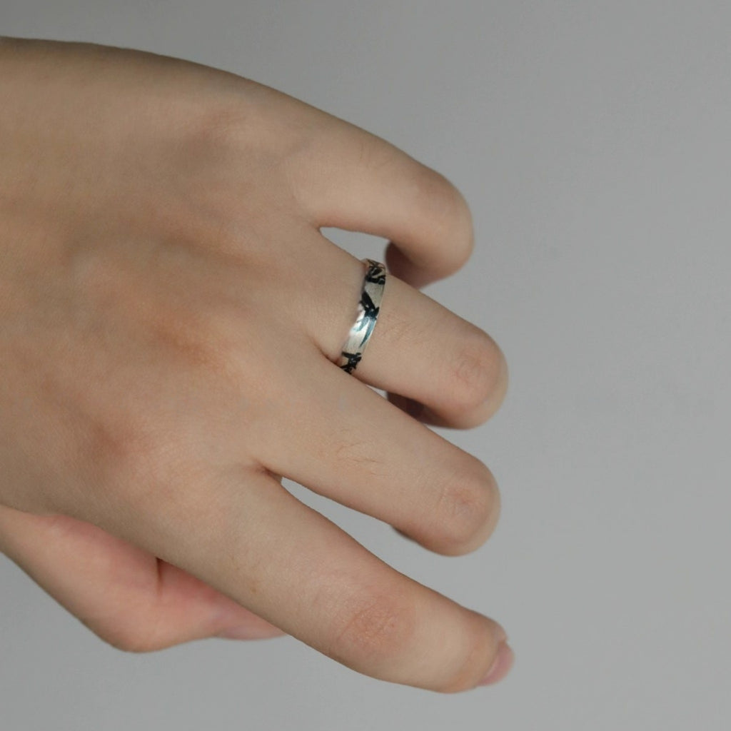 Hand wearing a silver ring on a plain background LacLume HandPainted Lacquer Ring Hand Drawn Bamboo Shadows Aesthetic Vibe