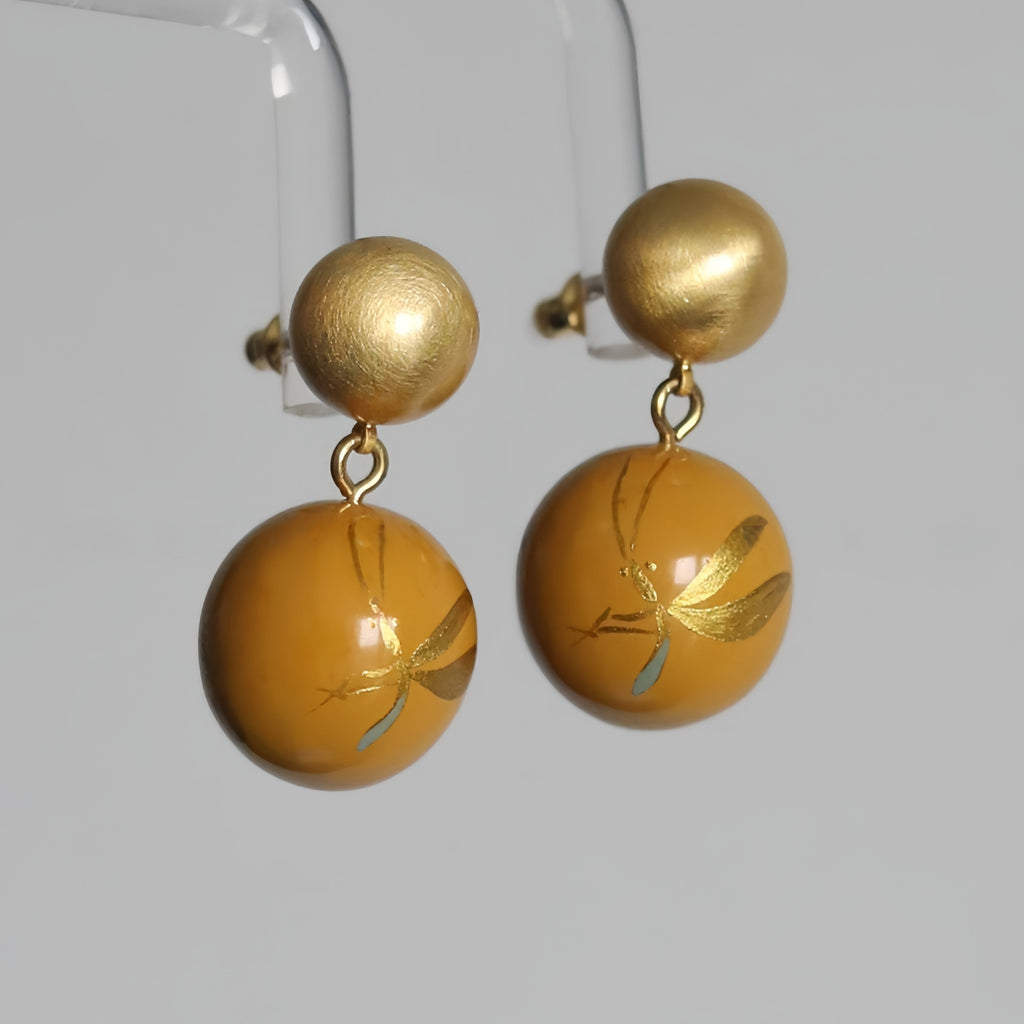 Gold and yellow earrings on a clear stand against a white background LacLume Summer Firefly Handmade Lacquer Jewelegant Temperament Earringselry