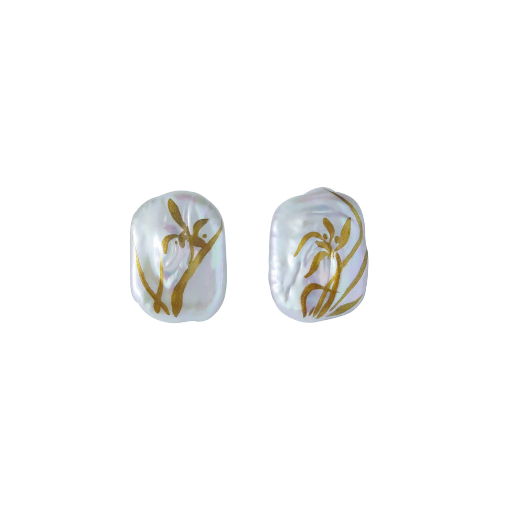 Pair of pearl earrings with gold floral designs on a white background