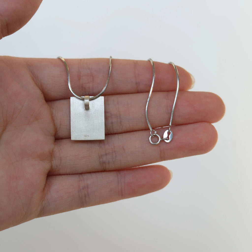 Hand holding a silver necklace and earring set against a white background LacLume Starry Sky Cosmos Flower Necklace Hand-Painted Lacquer Dreamy Vibe