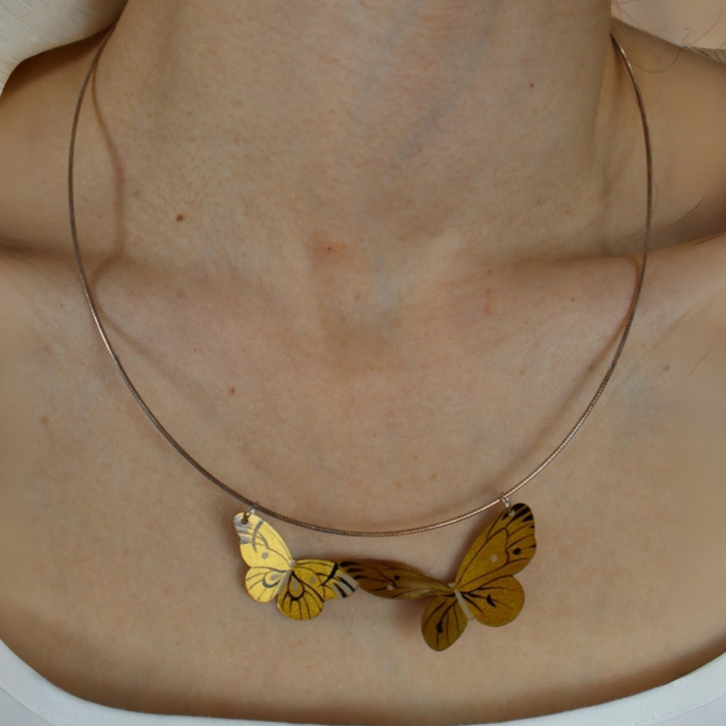 Necklace with butterfly pendants on a plain background