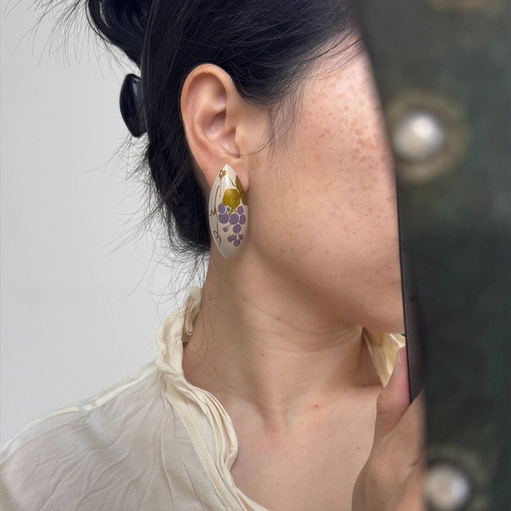Close-up of a person wearing floral earrings with a neutral background LacLume Handcrafted Lacquer Earrings Purple Berry Bubbles Niche Daily Style