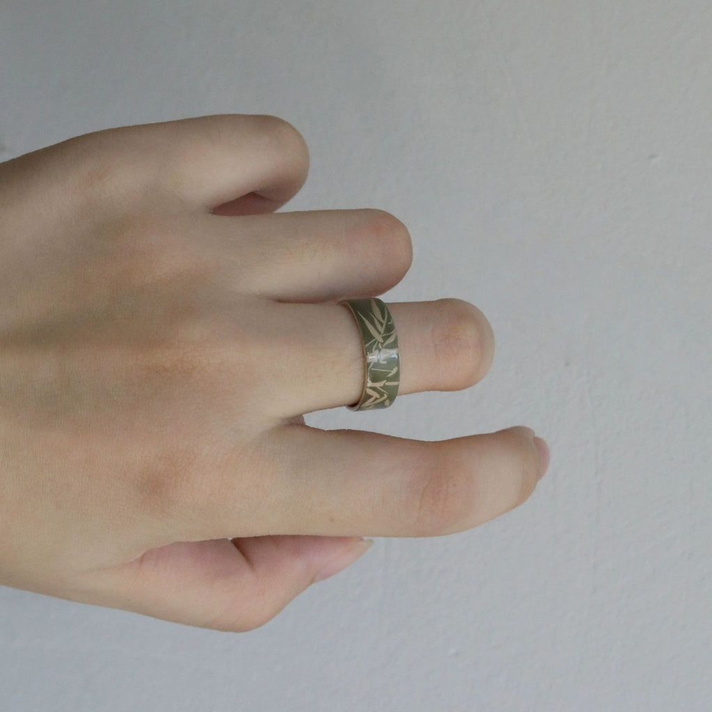 Hand wearing a ring with a subtle pattern on a plain background LacLume HandPainted Lacquer Silver Ring Bamboo Pattern Handmade Silver Lacquerware