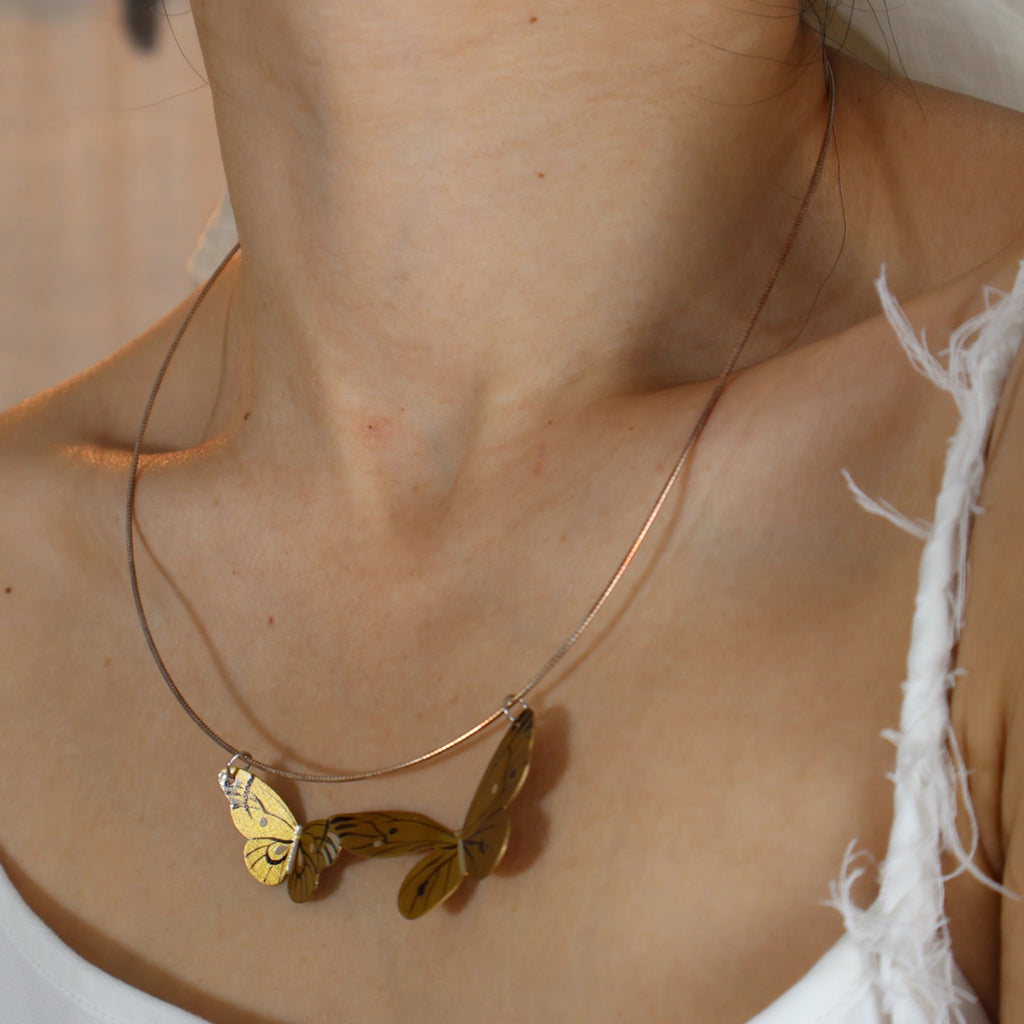 Necklace with butterfly pendants on a person's neck