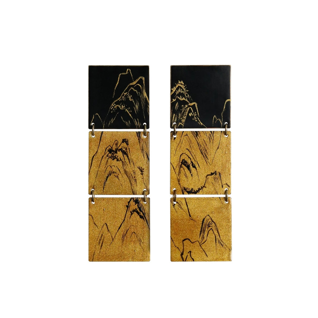 Set of four square cork coasters with black mountain designs on a white background