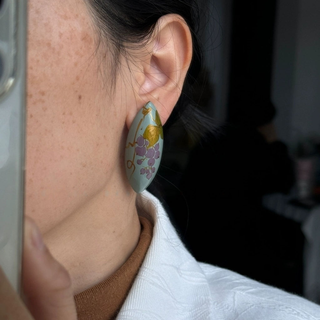 Close-up of an ear wearing a floral earring with a blurred background LacLume Handcrafted Lacquer Earrings Purple Berry Bubbles Niche Daily Style