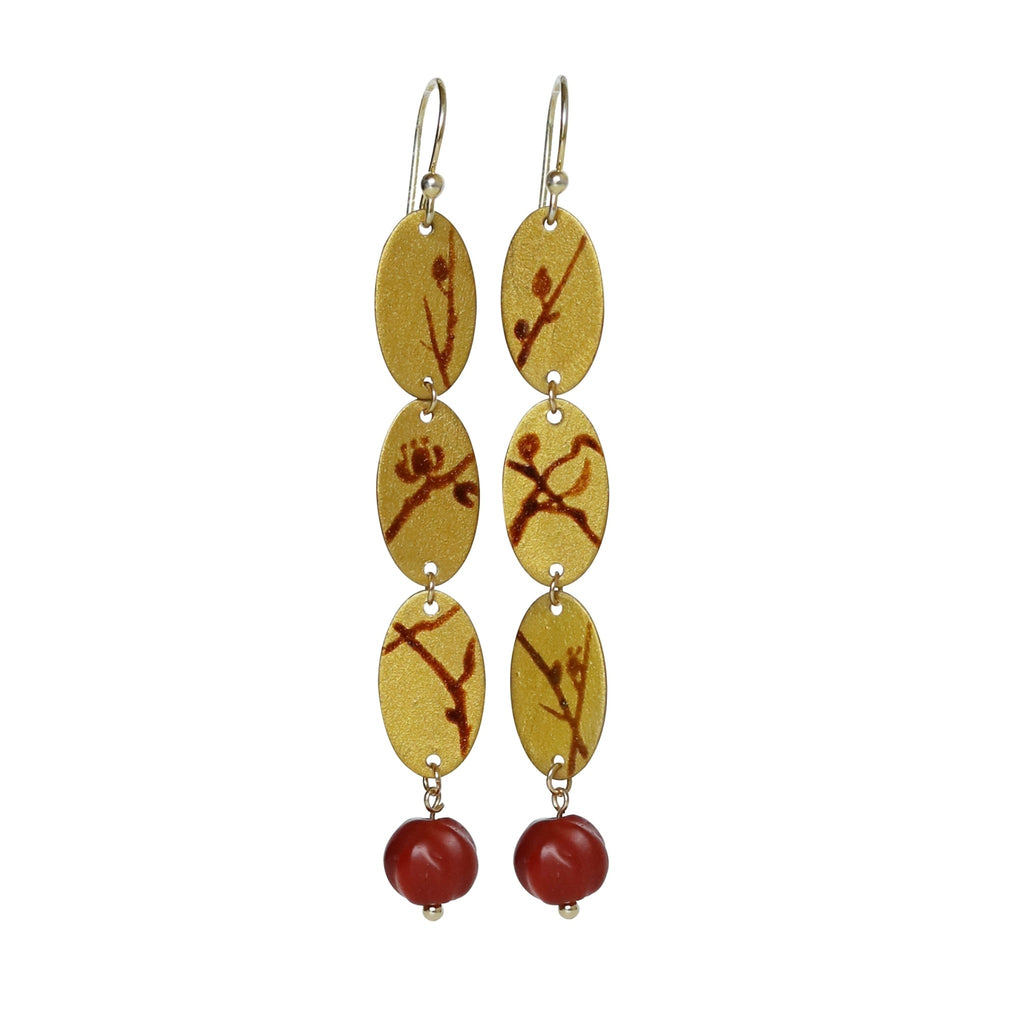 Pair of earrings with yellow and red oval-shaped beads on a white background