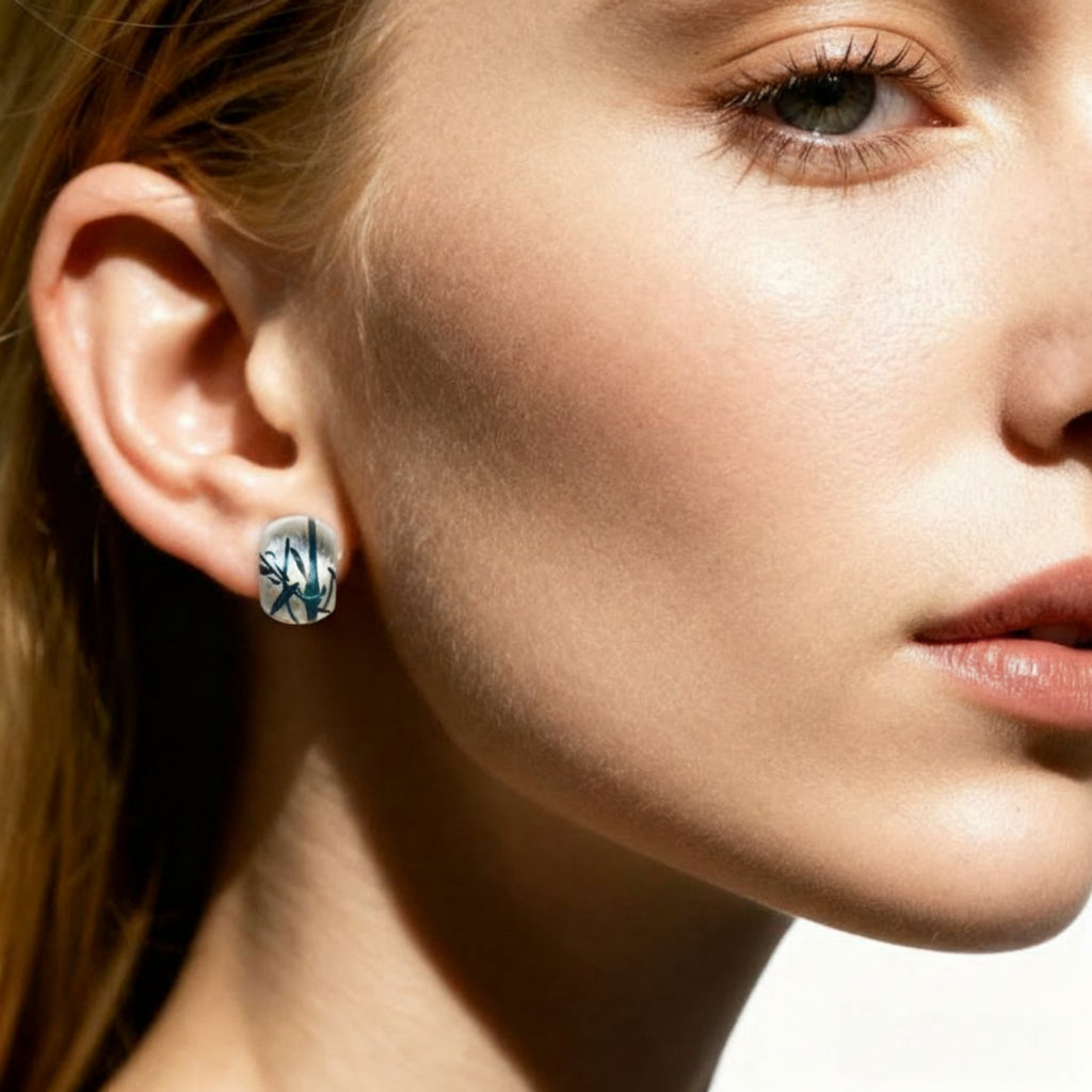 Close-up of a woman wearing a silver earring with a tree design.