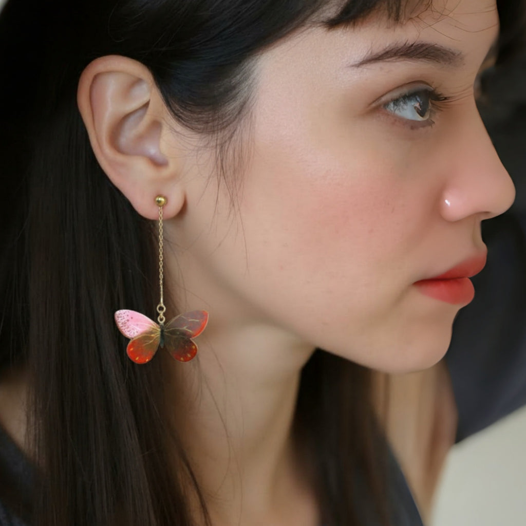 Close-up of a woman wearing butterfly-shaped earrings.