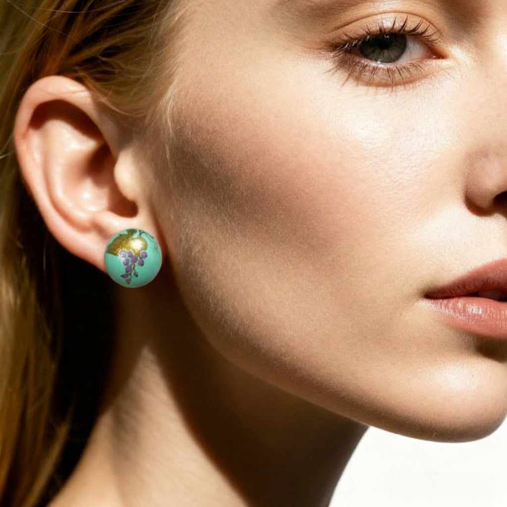 Close-up of a woman wearing a turquoise earring with a floral design.