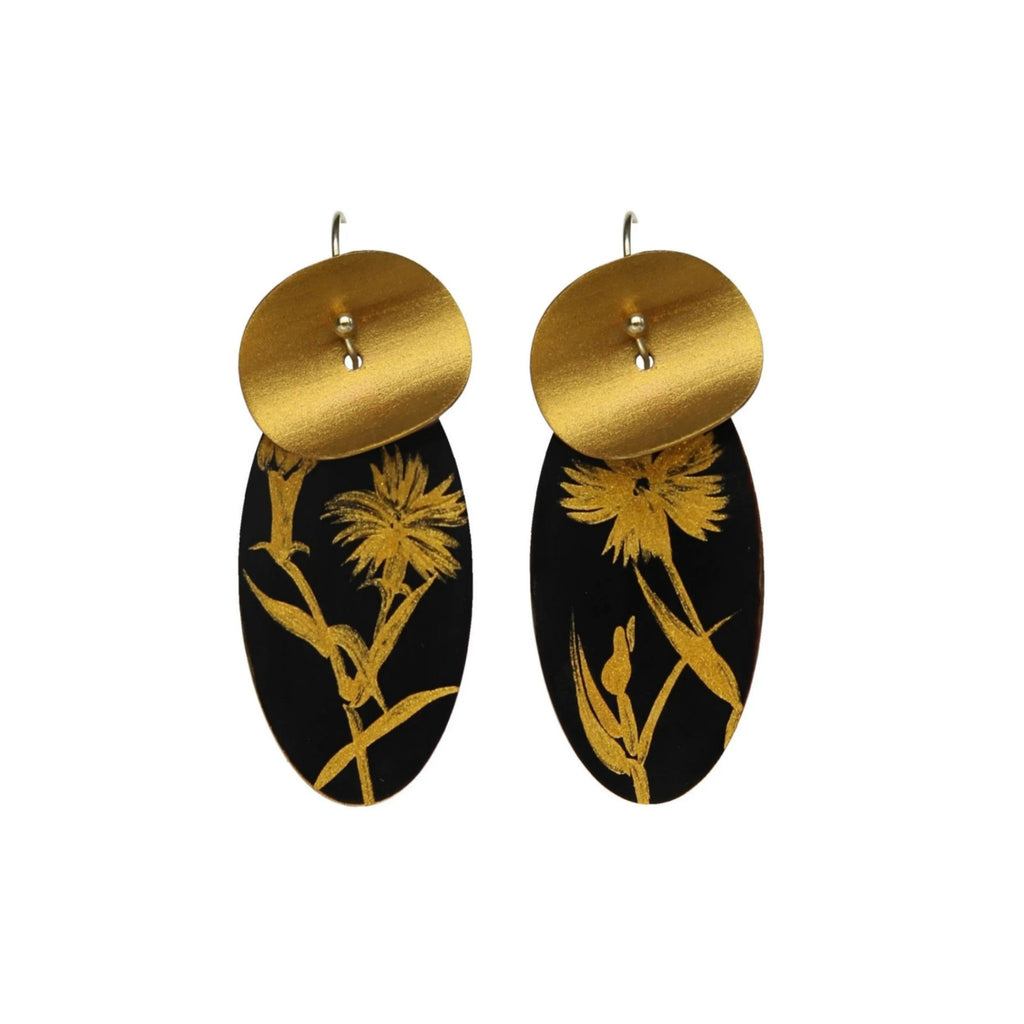 Pair of earrings with gold and black design on a white background