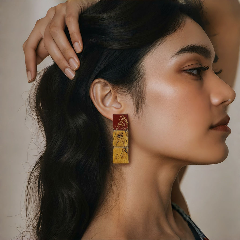 Woman wearing a unique earring with geometric design LacLume Retro Style Lacquer Earrings HandPaintedd Mountain Peaks